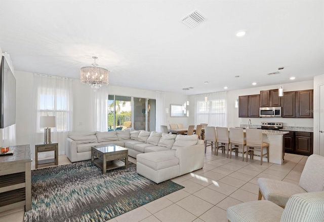 living room featuring light tile patterned floors and an inviting chandelier