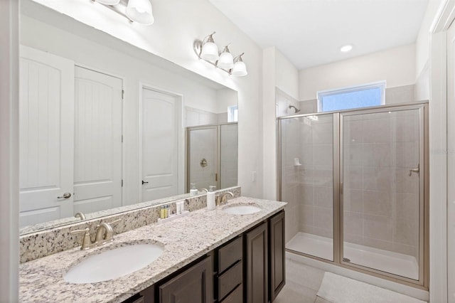 bathroom with tile patterned flooring, vanity, and a shower with shower door