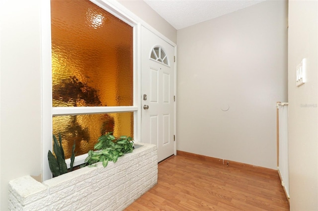 hall featuring a textured ceiling and light hardwood / wood-style flooring