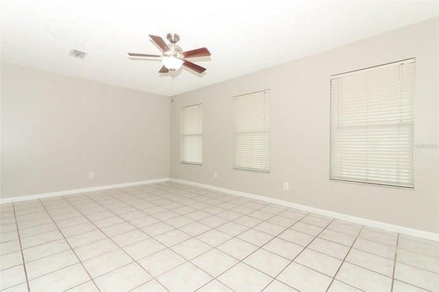 tiled spare room featuring ceiling fan