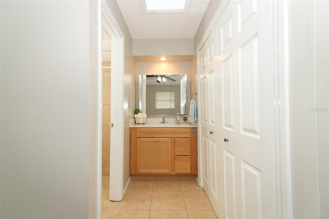 bathroom with a textured ceiling, ceiling fan, vanity, and tile patterned floors