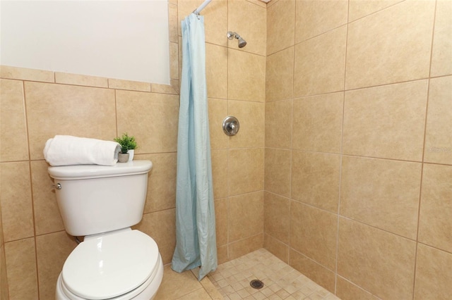 bathroom with toilet, tile walls, and a shower with shower curtain