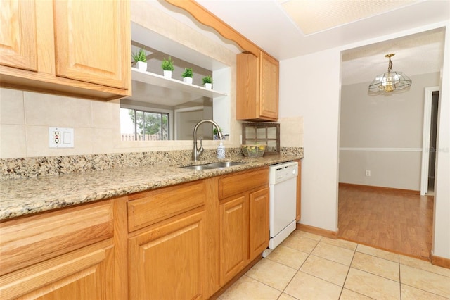 kitchen with light stone countertops, white dishwasher, decorative backsplash, sink, and light tile patterned flooring