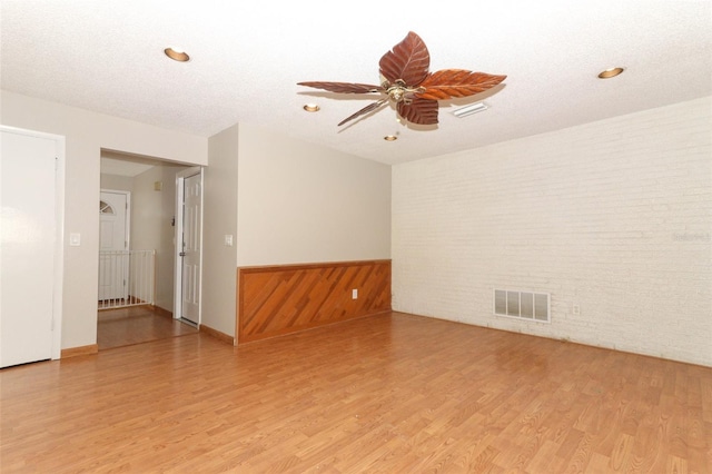 spare room with a textured ceiling, ceiling fan, and hardwood / wood-style floors