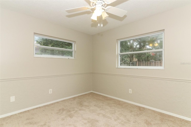 spare room with a textured ceiling, ceiling fan, and light carpet