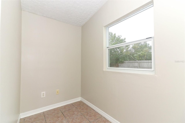 tiled spare room with a textured ceiling