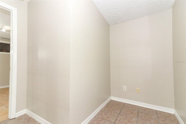 interior space with a textured ceiling and light tile patterned floors