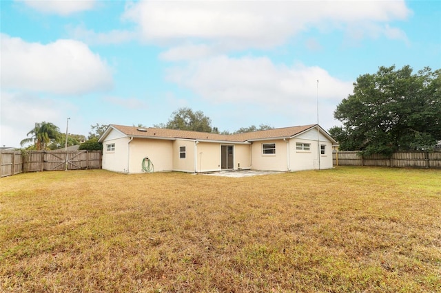 back of property featuring a patio area and a yard