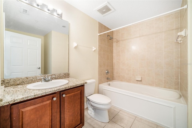 full bathroom with tile patterned flooring, vanity, a textured ceiling, toilet, and tiled shower / bath