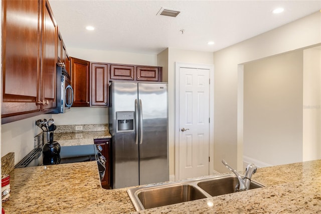 kitchen with sink, stainless steel appliances, kitchen peninsula, and light stone countertops