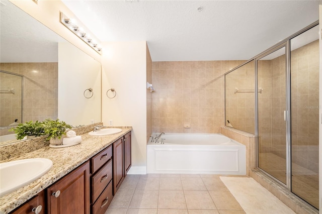 bathroom with tile patterned flooring, vanity, plus walk in shower, and a textured ceiling