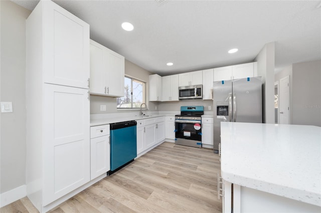 kitchen featuring white cabinets, sink, stainless steel appliances, and light hardwood / wood-style floors