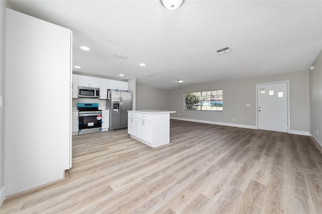 kitchen with white cabinetry, a textured ceiling, stainless steel appliances, and a center island