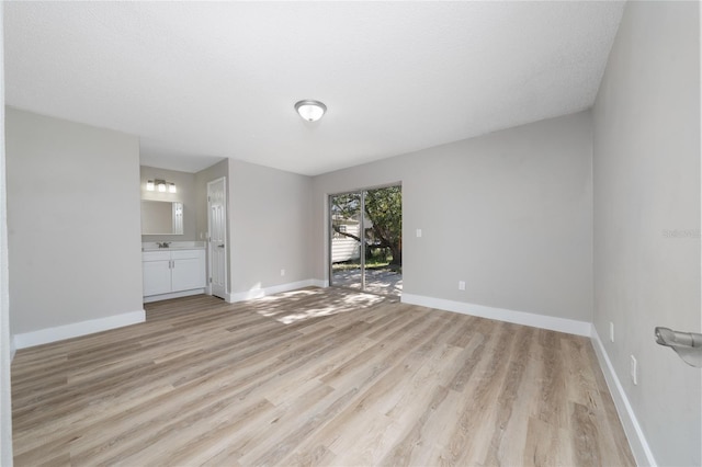 empty room with light hardwood / wood-style floors and a textured ceiling