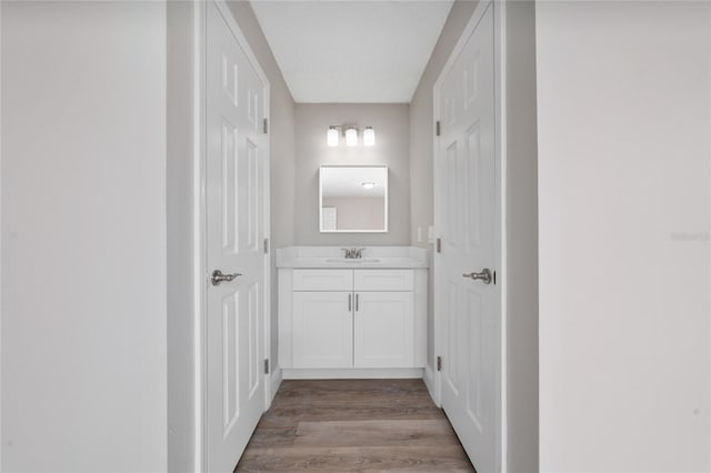 hallway with sink and light hardwood / wood-style flooring