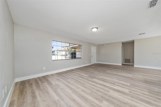 empty room featuring a textured ceiling and light wood-type flooring