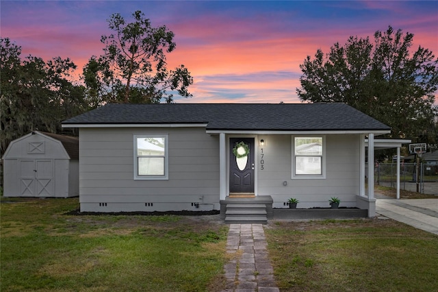 view of front of property featuring a storage unit and a yard