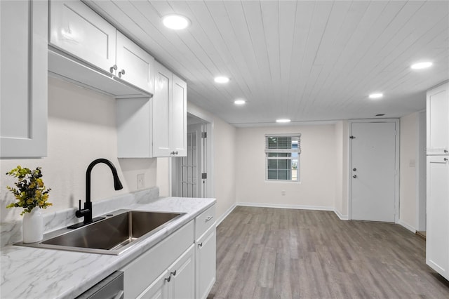 kitchen featuring light stone counters, white cabinets, light hardwood / wood-style flooring, and sink