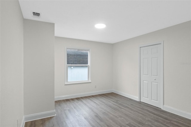 spare room featuring wood-type flooring