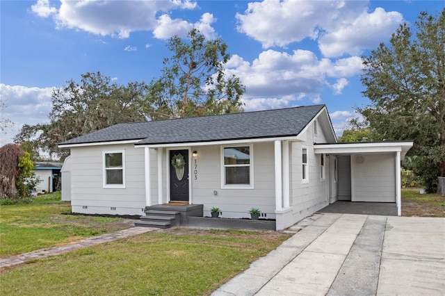 view of front of property with a front yard and a carport