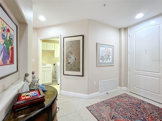 tiled foyer featuring washer and clothes dryer