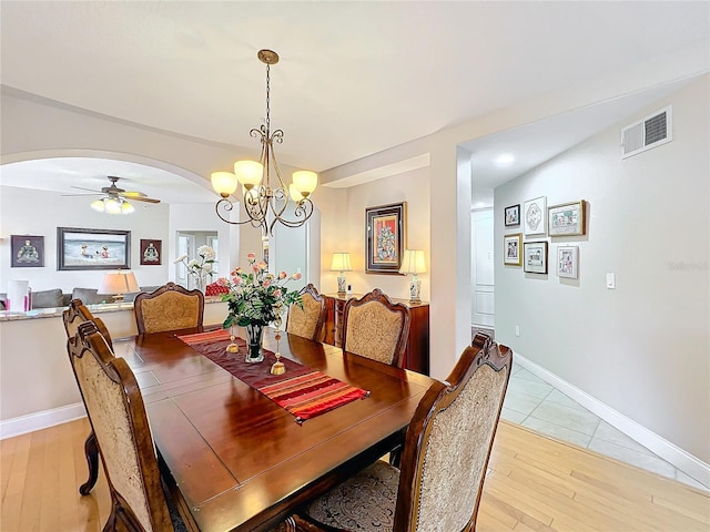 dining room featuring ceiling fan with notable chandelier and light wood-type flooring