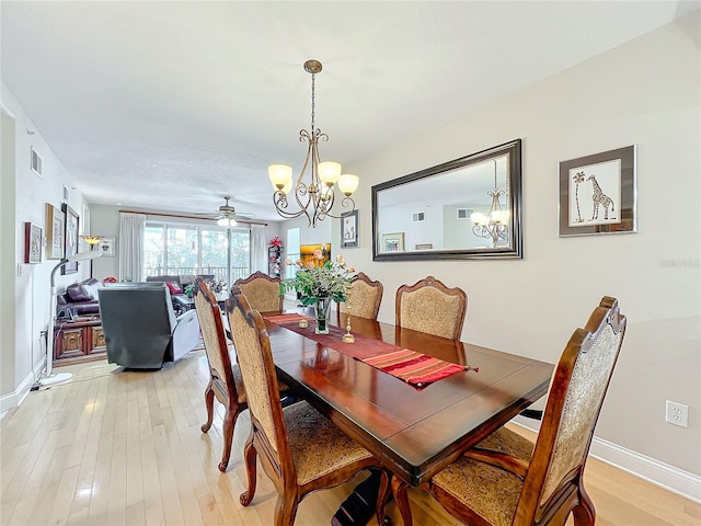 dining room featuring ceiling fan with notable chandelier and light hardwood / wood-style floors