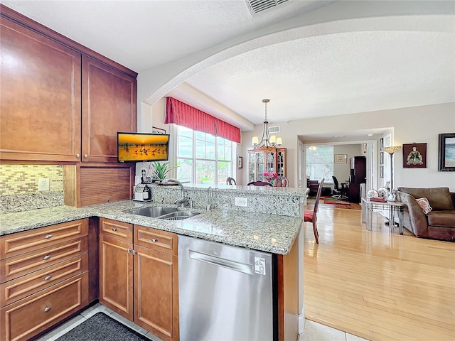 kitchen featuring dishwasher, sink, backsplash, and kitchen peninsula