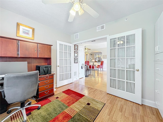 office area featuring a textured ceiling, french doors, ceiling fan, and light wood-type flooring