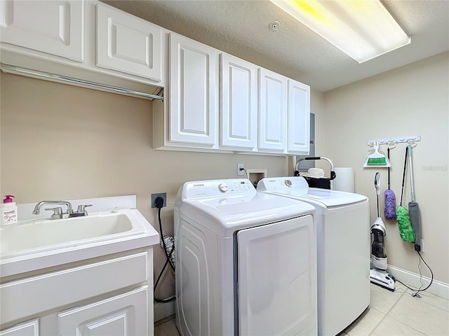 washroom with cabinets, sink, light tile patterned floors, and washer and clothes dryer