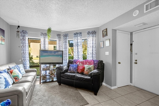 tiled living room featuring a textured ceiling