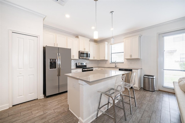 kitchen featuring white cabinetry, sink, stainless steel appliances, and a kitchen island