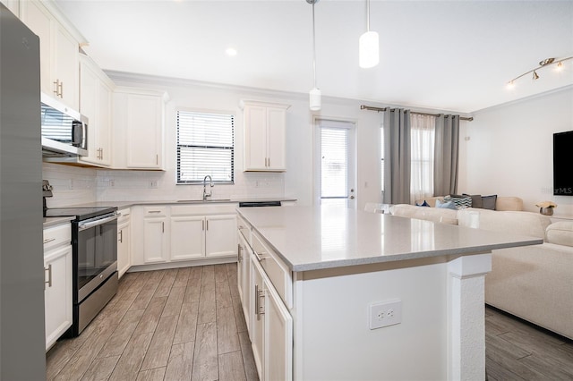 kitchen featuring white cabinetry, sink, a kitchen island, and appliances with stainless steel finishes