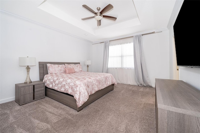 carpeted bedroom with a tray ceiling and ceiling fan