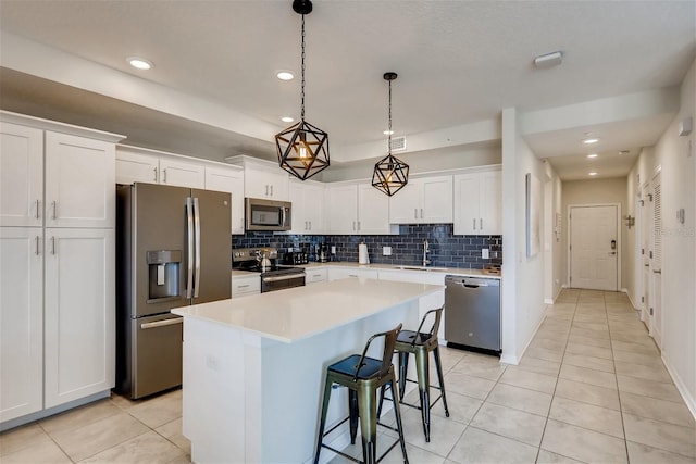 kitchen featuring stainless steel appliances, a kitchen island, and white cabinets