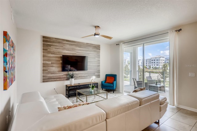 living room featuring light tile patterned flooring, a textured ceiling, and ceiling fan