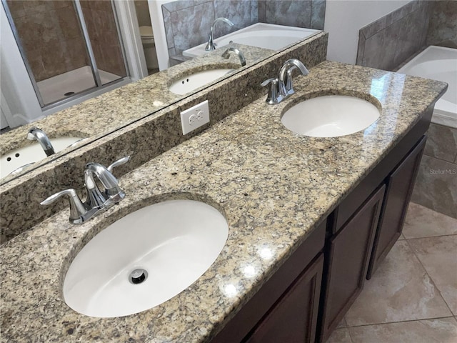 bathroom featuring tile patterned flooring, shower with separate bathtub, and vanity