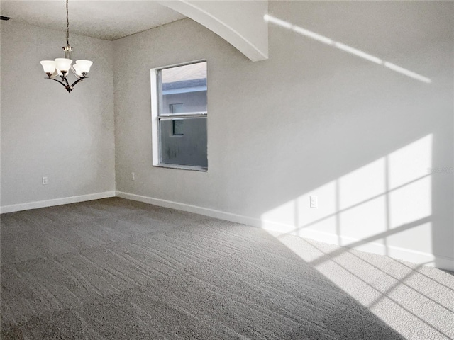 carpeted spare room with a notable chandelier