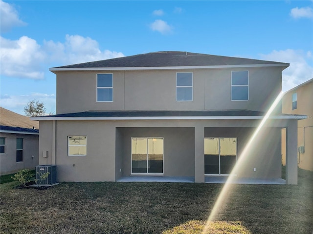 rear view of property featuring a patio area, central AC unit, and a lawn