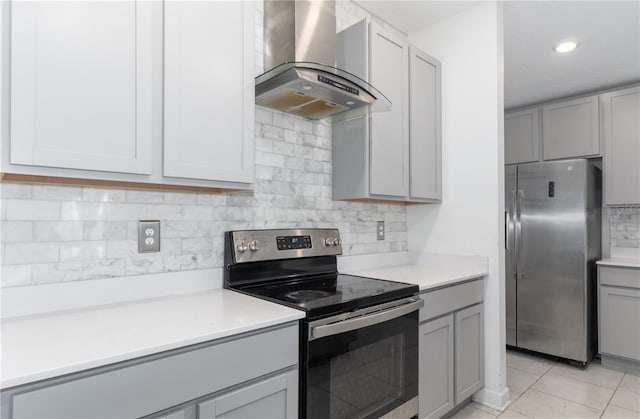 kitchen with stainless steel appliances, extractor fan, gray cabinetry, and light tile patterned flooring