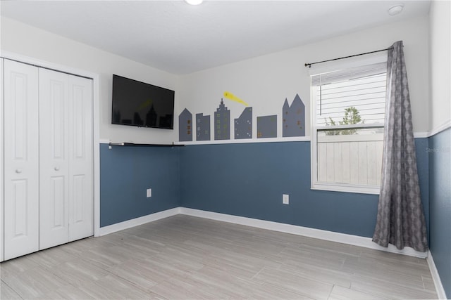 unfurnished bedroom with wood-type flooring and a closet