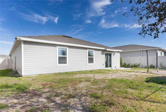 back of house with a lawn