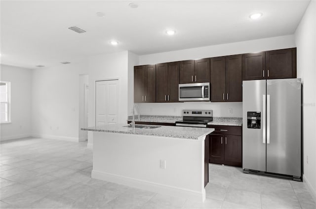 3179 W Barberton Pl, Citrus Springs, FL 34433 - kitchen featuring stainless steel appliances, a center island with sink, dark brown cabinetry, recessed lighting, and light stone counters
