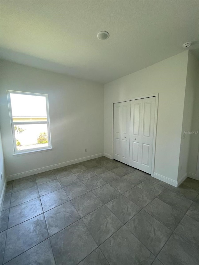 3179 W Barberton Pl, Citrus Springs, FL 34433 - unfurnished bedroom with a closet and tile patterned flooring