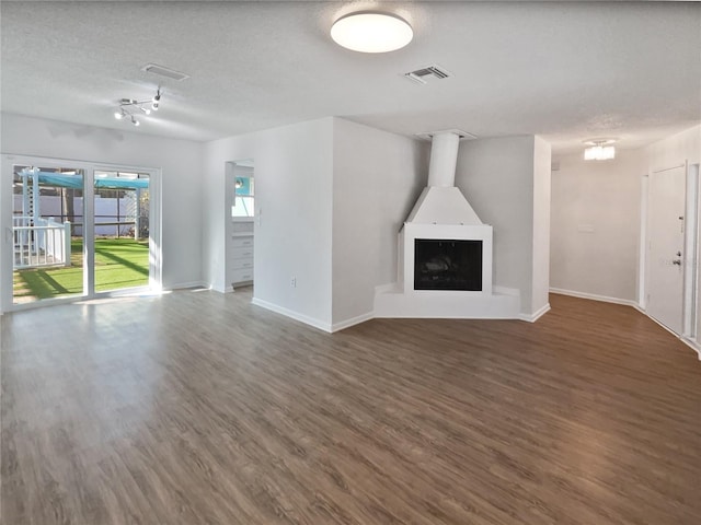 unfurnished living room featuring a textured ceiling and dark wood-type flooring