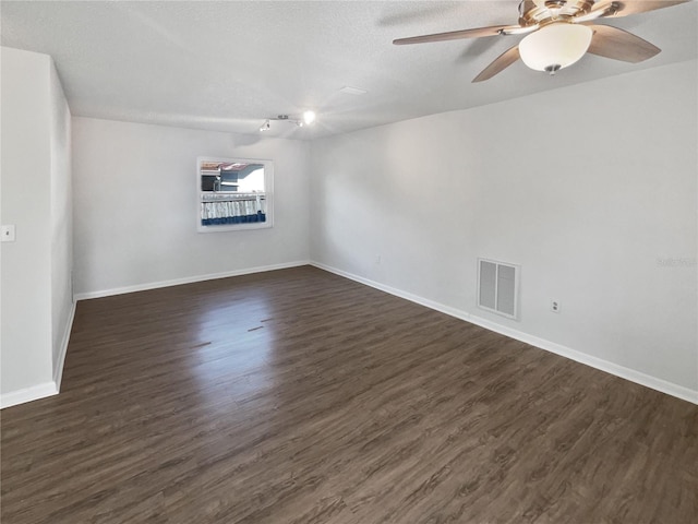 spare room with dark wood-type flooring, a textured ceiling, and ceiling fan