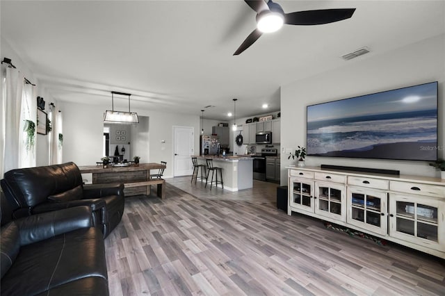 living room featuring ceiling fan and hardwood / wood-style floors