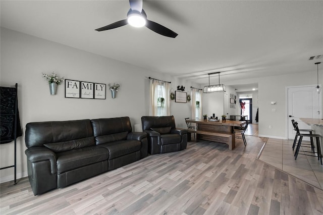 living room with ceiling fan, plenty of natural light, and hardwood / wood-style flooring