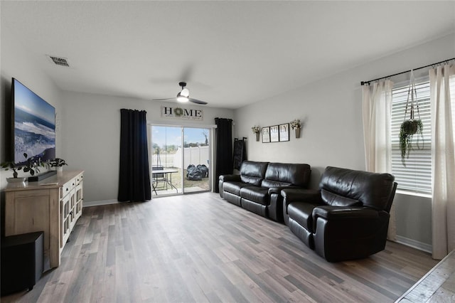 living room featuring ceiling fan, plenty of natural light, and hardwood / wood-style flooring