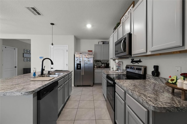 kitchen featuring stainless steel appliances, sink, pendant lighting, a kitchen island with sink, and gray cabinetry